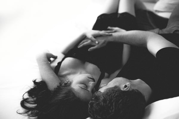 A couple lying down head to head, seen from above, in black and white