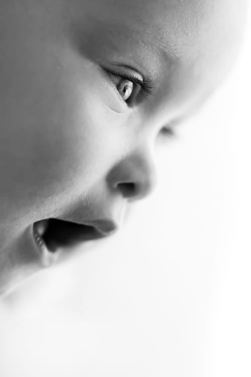 Close detail of a newborn's open eye and cheek