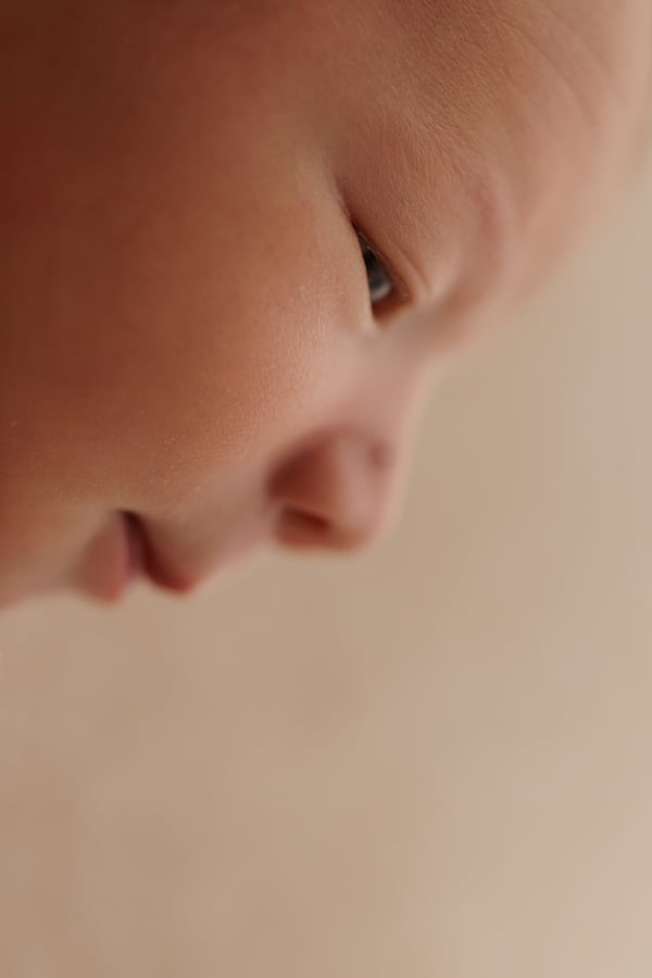 Very close view of a newborn's open eye and nose